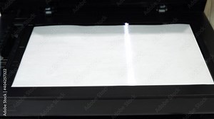 Document scanning process. Scanner in operation scans a sheet of paper with the cover open