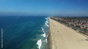 Very high view over Huntington Beach with almost no people and some large waves breaking on the shore.