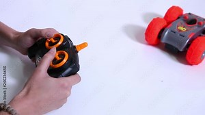 Woman operating radio controlled red toy sports car.