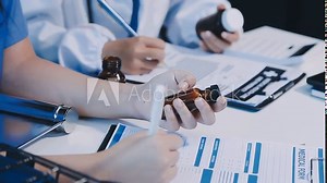Closeup hand of male pharmacist counting and arrange pills on qualified stainless counting tray with spatula in pharmacy. Pharmacist prepare medication in stainless tray by prescription at drugstore.