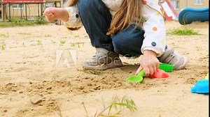 little child girl having fun on playground in sandpit. Toddler playing with sand molds and making mudpies. Outdoor creative activities for kids