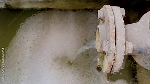 Dirty waste water coming out from pipe. Pouring water produce foam. Chemical waste water from industrial process. Wastewater Treatment Procedure (WWTP)