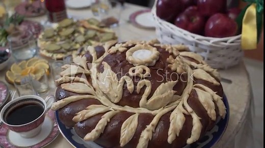Wedding bread - loaf (cake) on a rich table. A traditional symbol on the wedding day. The loaf is decorated with flowers, stables, ears of dough. The bride and groom. Ukrainian / Russian tradition .