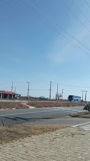 Blue Bus Journey Through Barren Landscape