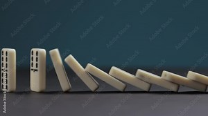 Falling dominoes. Chain reaction, built figure of dominoes falling in slow motion.