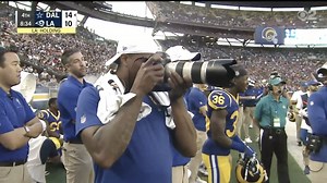 Marcus Peters takes photos from the sideline during preseason game