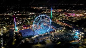 Illuminated Ferris Wheel At Orlando In Florida United States. Colorful Ferris Wheel. Illuminated City. Night Life Landscape. Illuminated Ferris Wheel At Orlando In Florida United States.