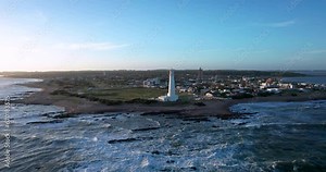 Sunny day in La Paloma, Rocha, Uruguay: The iconic lighthouse, located at the tip of the town. The drone makes a turn in orbit.