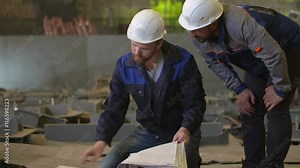 Engineers look at building plans and discuss stages of construction in heavy industry factory Stock Video