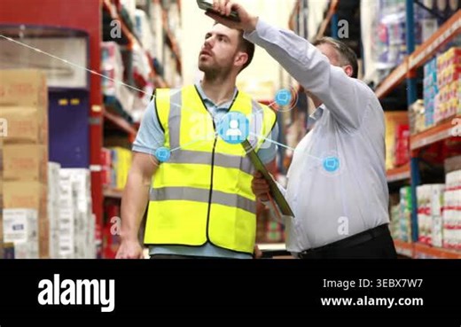Warehouse manager pointing with phone and holding clipboard, guiding worker as blue icons spreading. Distribution, logistics, inventory, workflow, collaboration, efficiency, industrial Stock Video Footage - Alamy