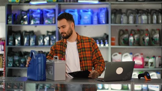 Auto parts store salesman managing inventory with laptop