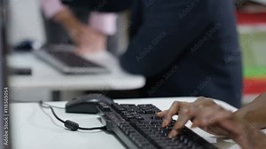 Teacher showing student how to use computer in adult education class