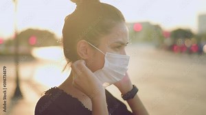 Beautiful woman wearing a surgical mask outdoor, covid-19 , health and pollution concept.