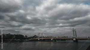 Motionlapse of Wandsworth Bridge with boats moored at embankment on beautiful cloudy day with a blue sky