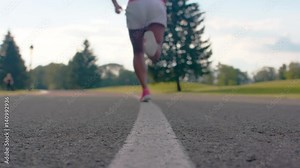 African woman legs in sport shoes start to run on asphalt road. Close up of female athlete legs start to run. Woman runner legs in sport sneakers running on park road. Closeup of runners feet on road