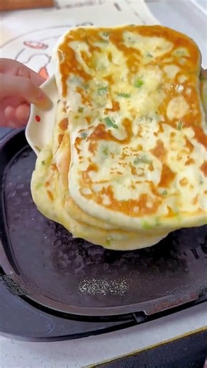 Crispy Naan Paratha Ingredients: 2 ½ cups all-purpose flour ½ tsp salt ¾ cup warm water (add as needed) 1 tbsp chopped scallions (green onion leaves) 1 tbsp oil (for dough) Seasoning Paste: 1 tbsp all-purpose flour 1 tsp garam masala or pepper 1 tbsp ghee or oil For Cooking: 2–3 tbsp oil or ghee Instructions: 1. Make the dough: In a bowl, mix flour, salt, and warm water. Knead until smooth. Rest 15 minutes. 2. Prepare the paste: Mix flour, garam masala, and ghee into a smooth paste. 3. Add scall