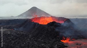Super slow-motion footage of a volcano erupting in Iceland, capturing lava explosions from the crater and molten lava flowing across the dark volcanic terrain.