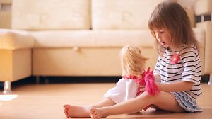 Little girl playing with a dolls