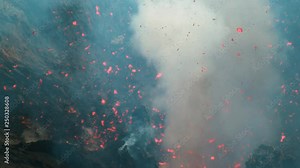 SUPER SLOW MOTION, CLOSE UP: Glowing particles of lava fall back to the ground after a violent eruption of Mount Yasur. Orange magma and mist are blasted out of the depths of an active volcanic crater