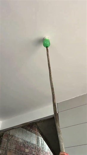 Ceiling light switch pressed using improvised stick tool