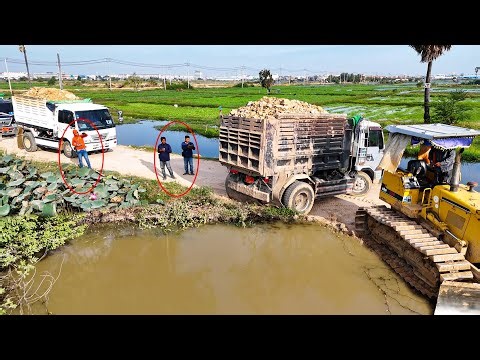 Great pushing bulldozer operator filling farm with soil and dump truck