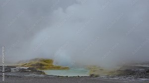 Experience the breathtaking spectacle of Old Faithful Geyser erupting in the stunning Yellowstone National Park. On a cloudy afternoon, the geyser reveals nature's incredible power and beauty