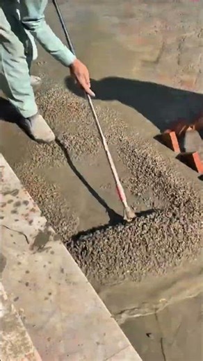 Professional workers are leveling the cement mixture they have poured.