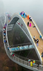 A bending, glass-bottomed bridge in Zhejiang has gone viral due to its peculiar shape and stunning views. Ruyi Bridge in Taizhou looks like a giant eye in the sky suspended between mountains, drawing visitors with the thrill of its transparent skywalk. #Summer #Travel #FunChina | China Plus Culture