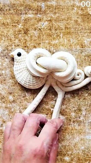 Holding handmade ceramic bird with textured surface