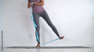 Resistance band fitness girl doing standing side lateral leg raise for hip abductor activation workout exercises with rubber strap elastic. Glute muscle activation training at home