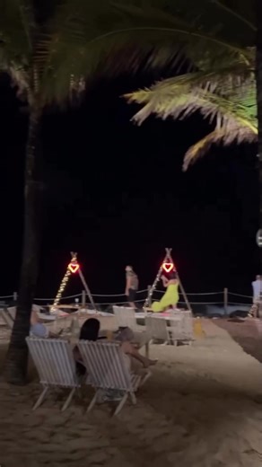 Fingindo tomar drink em barraca na praia à noite
