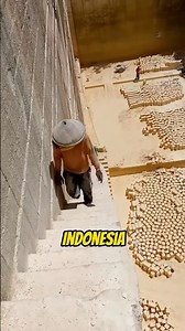 Workers cut giant limestone blocks by hand for building foundations