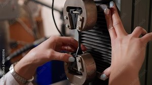 Female worker deals with the assembly of factory machine mechanism details. Assembling the details inside the equipment mechanism. Putting details in the mechanism during the assembly process.