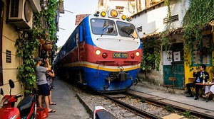 Watching a train travel between homes in Hanoi