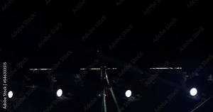 flashing and rotating light beams from stage lights on a construction during musical performance.