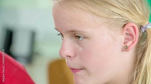 A girl is staring into a computer screen and she is learning computer basics.