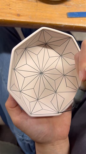 Love in Pottery on Instagram: "Mayuki Kato (@katomayuki_ceramics) is a fourth-generation ceramic artist from Seto, Japan—one of the country’s oldest pottery towns. Working from her family’s kiln, Singama (est. 1919), she brings new life to traditional Japanese ceramics through her refined sometsuke (blue underglaze) technique and striking contemporary patterns. Mayuki showcases her brushwork, painting a precise starburst pattern inside a faceted clay bowl. Using a handmade brush, she builds each