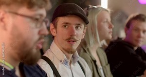 Young man experiences fear of revealing secret during public conversation. Face expression shows surprise and alertness. Human facial emotional reaction during socialization. Disclosure anxiety.