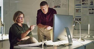 Getting each others take on the project at hand. 4k video of two colleagues working late on a computer in an office.