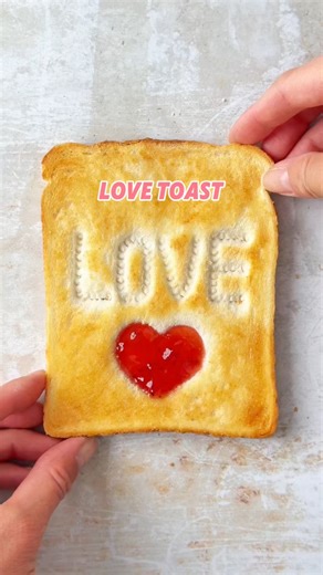An old favourite - this LOVE toast is an easy way to elevate your toast for a special occasion. Just use the end of a sauce bottle (or anything else you have to hand) to press in your ‘LOVE’ message and make a heart with a small spoon. Toast until golden, then butter and fill the heart with strawberry jam. #lovetoast #hotbutteredtoast #toastandjam #toastideas #love #specialbreakfast | The Fast Foodie