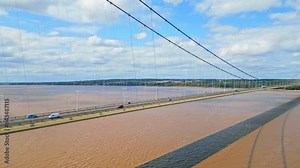 Enjoy the beauty of Humber Bridge through this aerial drone view. As the 12th largest suspension span worldwide, it graces the River Humber, linking Lincolnshire to Humberside amid traffic.