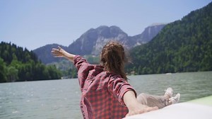 Young girl on catamaran sailing on mountain lake. Happy women resting on a boat. Family travel relaxing on water lake. Lifestyle Sailing Boat Healthy Female Living Freedom Travel Tourism