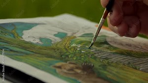 female artist paiting a jungle themed picture with watercolours, outdoors in a nature