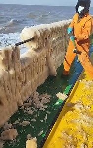 Dislodging ice from the railings of the fishing boat with a hammer. | Charity Bisteroso