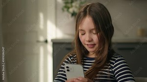 Little Caucasian girl holding mobile phone smartphone telephone internet communicate wifi texting sms chatting e-learning child preteen kid daughter typing networking messaging virtual web tech gadget