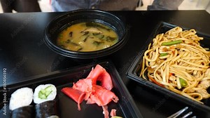 A man is eating Chinese food in a fast food restaurant. 4k. Slow motion. he eats soup from a disposable plate