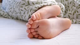 The child's bare feet sticking out from under the blanket. The kid...