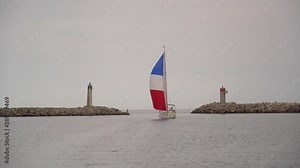 France flag sailing yacht sailing at a port between two lighthouses