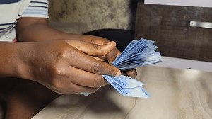 happy nigerian lady counting the new naira note