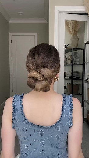 Try this hair hack if you want a fuller-looking bun! Gather your hair into a ponytail and secure it with a scrunchie. Split the ponytail horizontally into two equal sections. Tilt your head slightly forward and spread out the hair to cover the scrunchie. Wrap a hair tie over the bun. Gently pull and stretch the bun to make it bigger. Gather the excess hair at the nape of your neck. Split the hair in half. Bring the two sections above the bun together and secure with a clear elastic making sure t